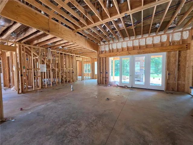 Great room with 12' ceilings overlooking back porch with fireplace and wooded view.
