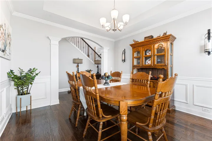 Gleaming hardwood floors and classic wainscoting define this elegant formal dining space.
