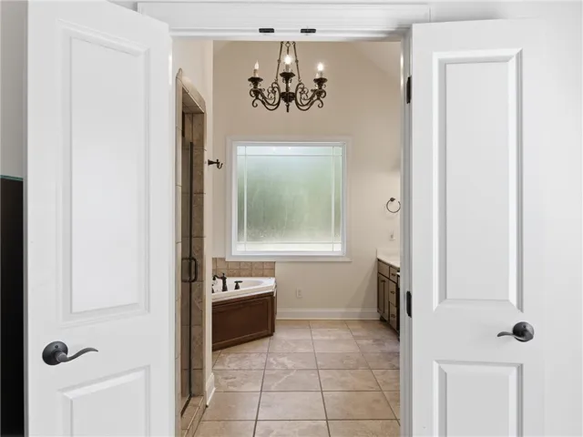 Primary Bath with Tile Flooring & chandelier