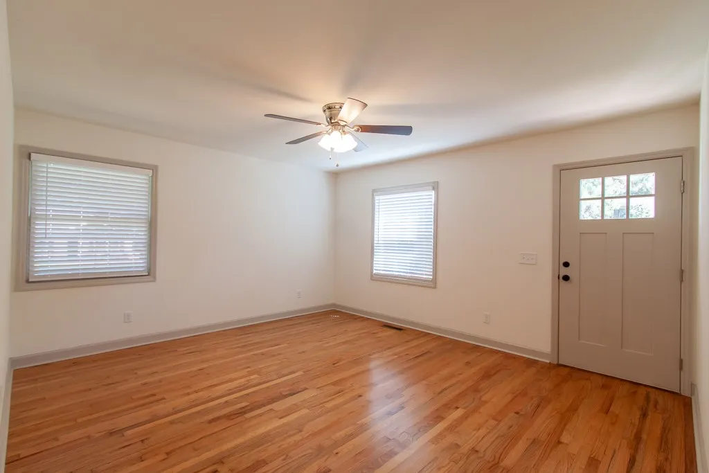 Polished wood flooring and natural light create a welcoming ambiance upon entry.
