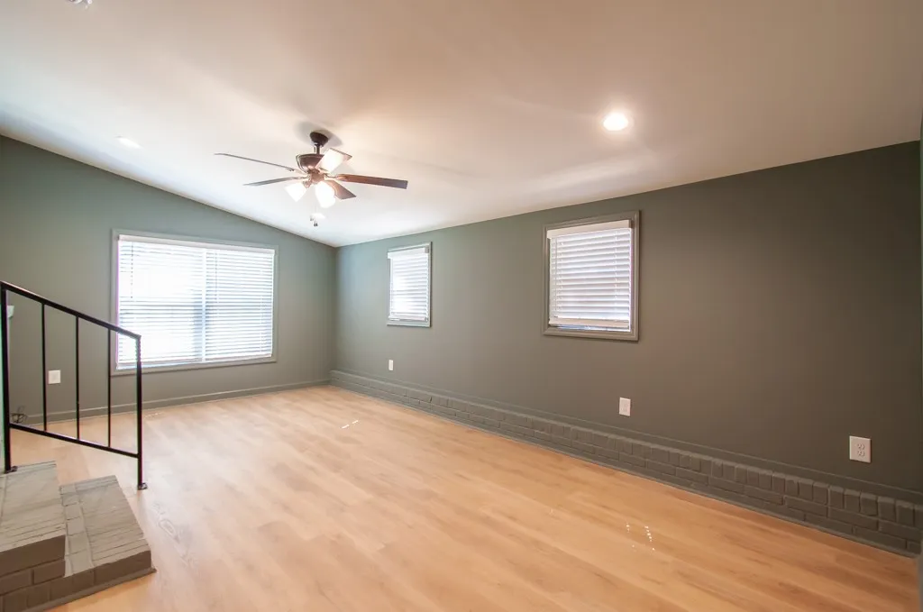 Warm wood flooring and soft recessed lighting complement the clean lines of this open space.