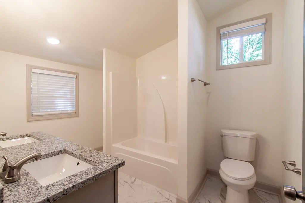Granite counters and tiled floors define this clean guest bathroom space.