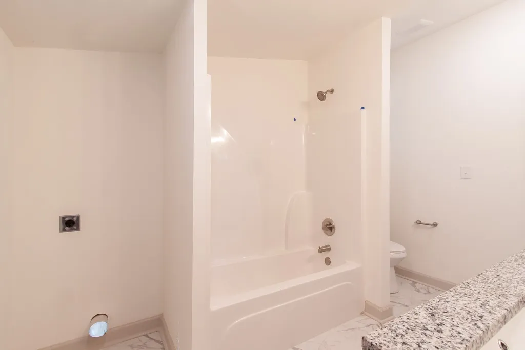 Polished stone counters and clean architectural lines define this modern bathroom space.