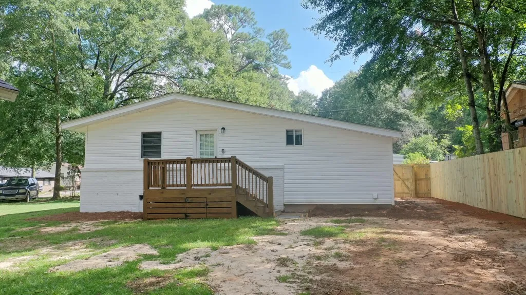 A spacious backyard area is framed by a newly installed wooden privacy fence.