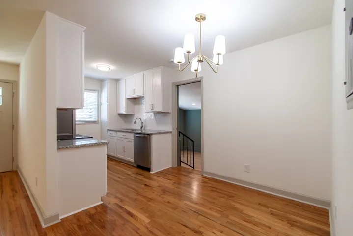 Gleaming hardwood floors flow from the bright dining area directly into the modern kitchen.