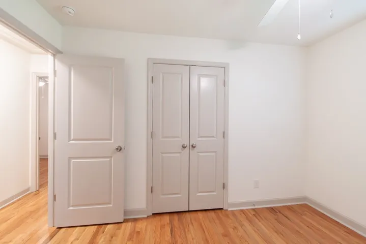 Rich hardwood floors and classic paneled doors define this clean, versatile bedroom space.