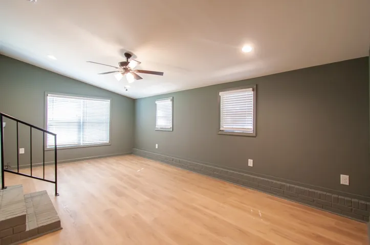 Warm wood flooring and soft recessed lighting complement the clean lines of this open space.
