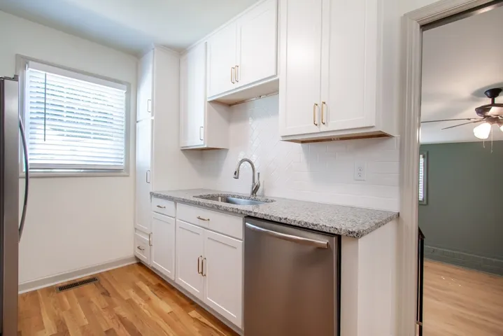 Granite countertops and clean white cabinetry highlight this beautifully updated kitchen.