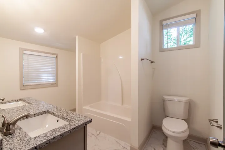 Granite counters and tiled floors define this clean guest bathroom space.