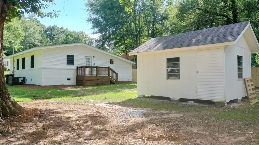 A spacious backyard features a functional wooden deck and a detached storage shed.