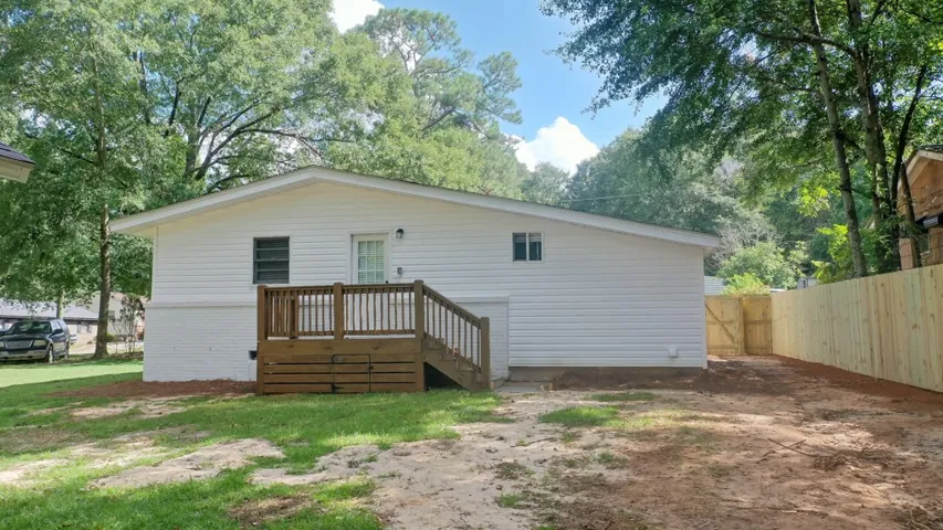 A spacious backyard area is framed by a newly installed wooden privacy fence.