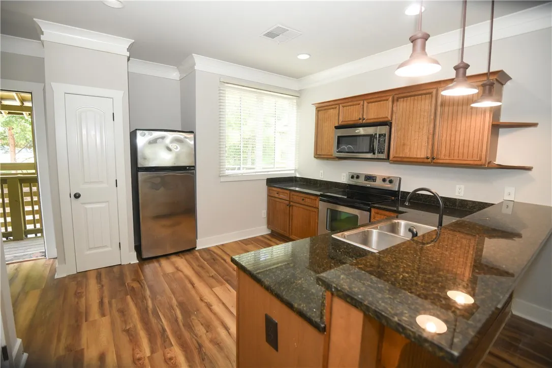 Polished granite countertops and classic wood cabinetry enrich this well-designed kitchen space.