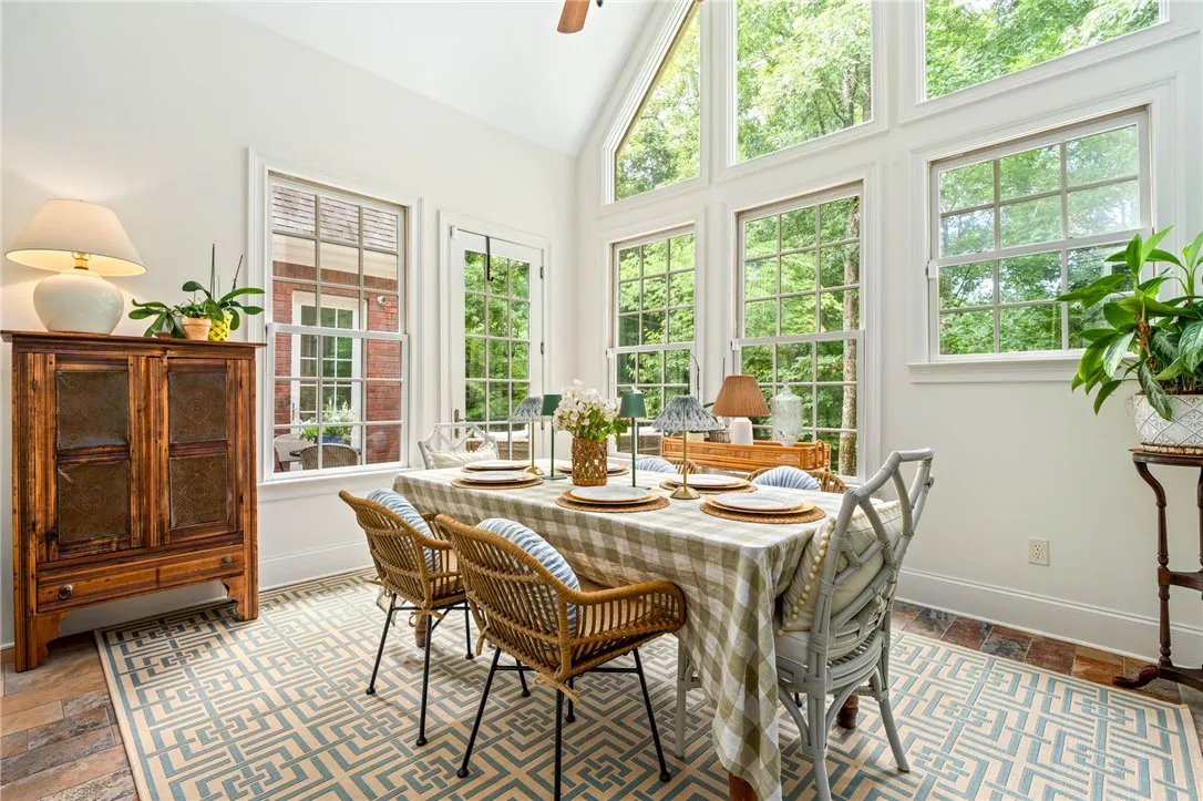 Towering windows rise toward the vaulted ceiling, bathing the dining space in serene natural light.