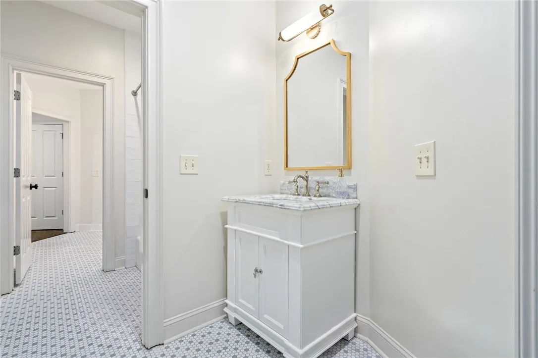 Timeless patterned tile flooring pairs beautifully with a single vanity on the other side of the jack-n-jill bathroom.