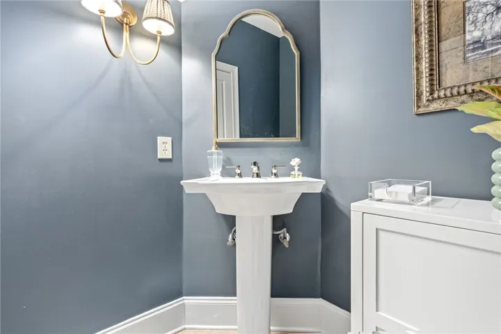 A classic pedestal sink anchors this classic main floor powder room setup.