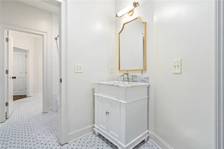 Timeless patterned tile flooring pairs beautifully with a single vanity on the other side of the jack-n-jill bathroom.