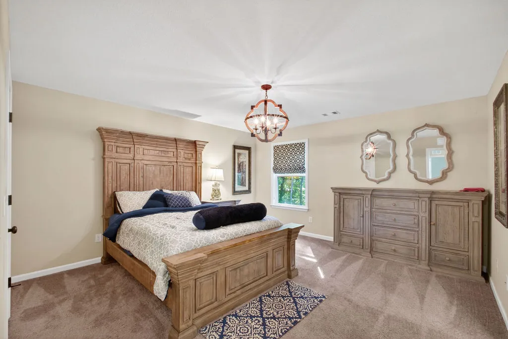An inviting sleeping space with a statement chandelier and abundant natural light.