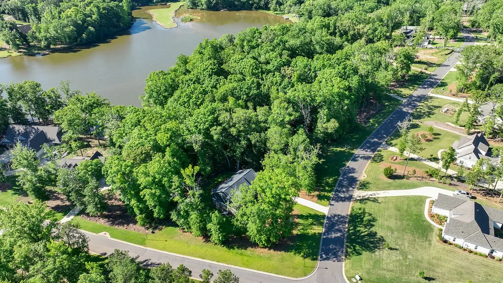 Perched by the water, a secluded home awaits amidst a verdant canopy of mature trees.