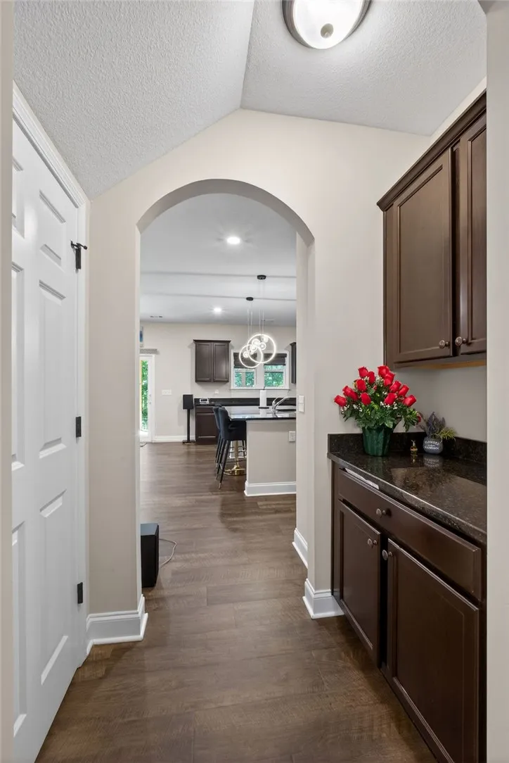 An inviting arched doorway leads to a spacious kitchen with a breakfast bar.