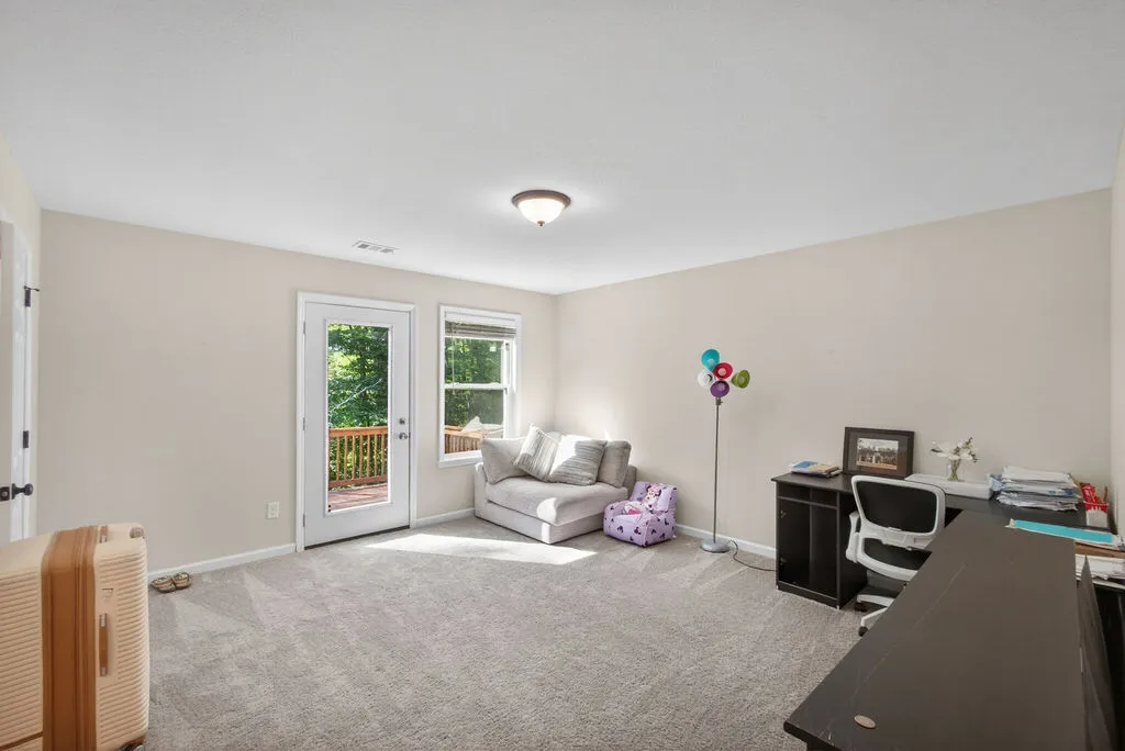 A versatile room provides comfortable living space and an exterior deck access.