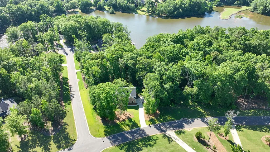 Perched on an expansive, verdant lot, this charming residence offers a secluded, lakeside retreat.