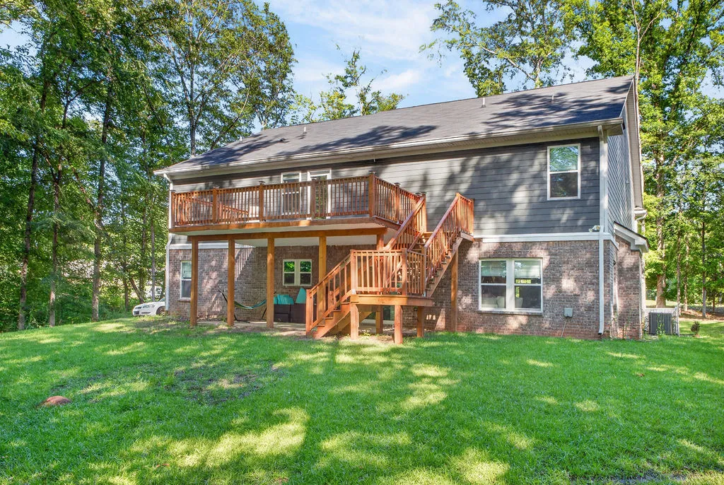 A spacious wooden deck and staircase extend from this home's exterior, offering an elevated outdoor living space.