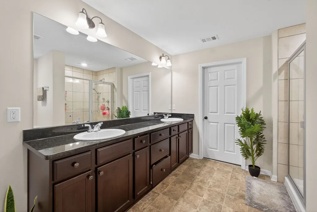 Dual vanity with dark cabinetry offers both form and function in this primary bathroom.