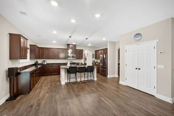 A contemporary kitchen showcasing rich cabinetry, sleek countertops, and a central island with seating.