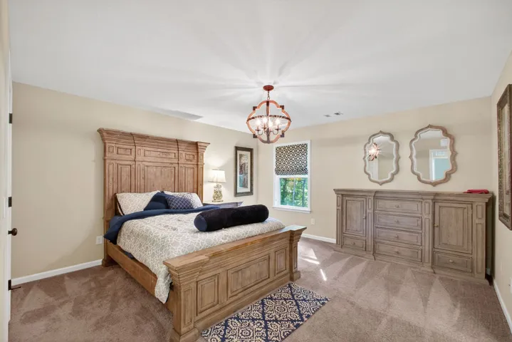 An inviting sleeping space with a statement chandelier and abundant natural light.