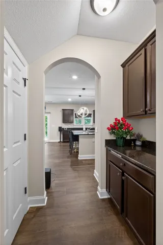 An inviting arched doorway leads to a spacious kitchen with a breakfast bar.