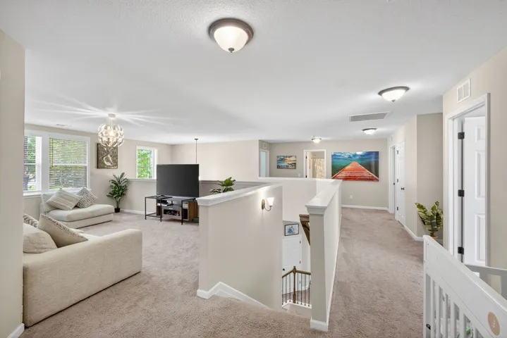 An inviting upstairs bonus area with a grand staircase and ample space for leisure.
