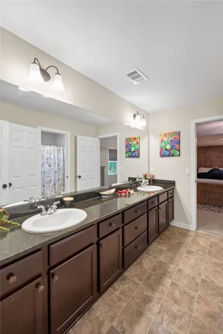 Double vanity with ample storage and stone counters elevates daily routines.