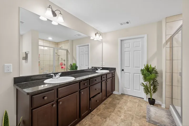 Dual vanity with dark cabinetry offers both form and function in this primary bathroom.