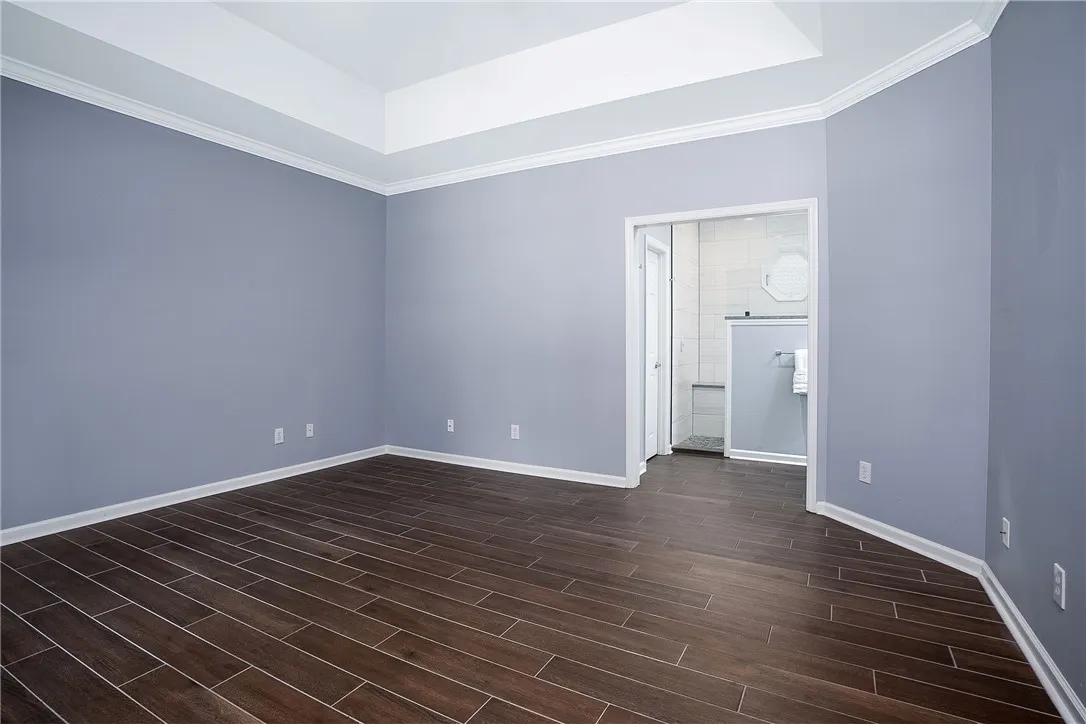 Primary Bedroom with Updated Flooring into Fully Renovated Primary Bathroom