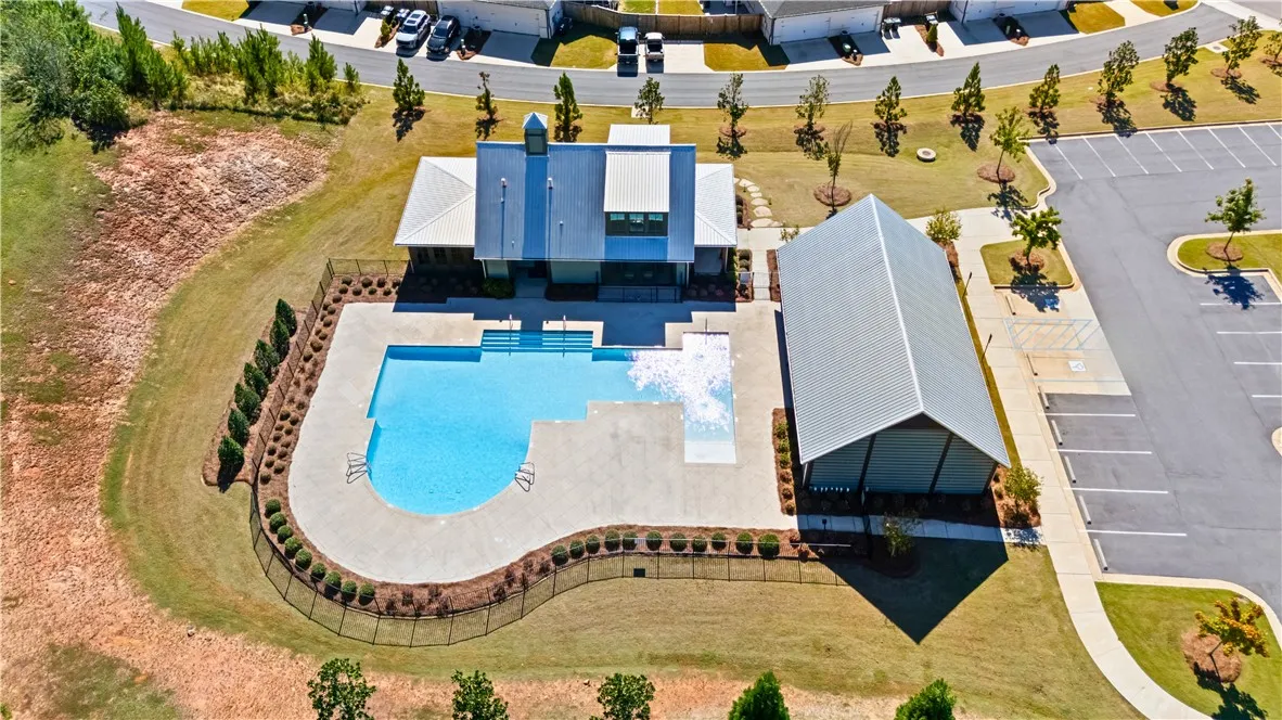 An aerial perspective showcases a sparkling community pool, clubhouse & covered pavilion.