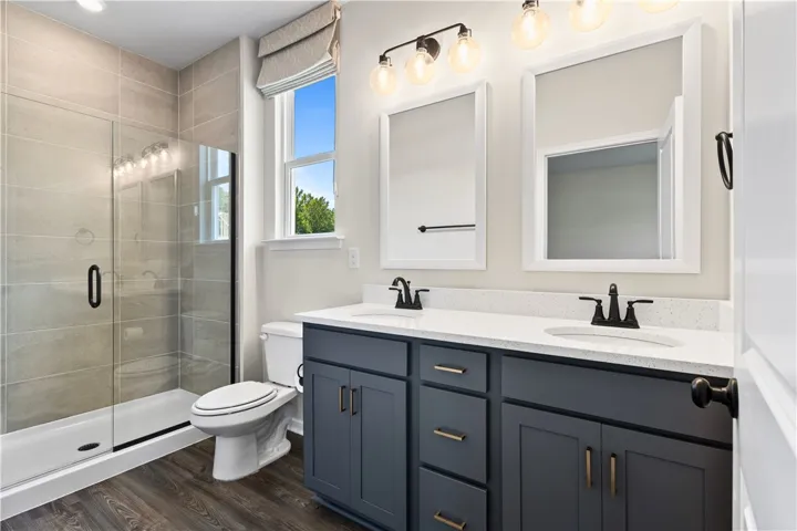 An elegant double vanity pairs with a glass-enclosed shower in this modern bathroom.