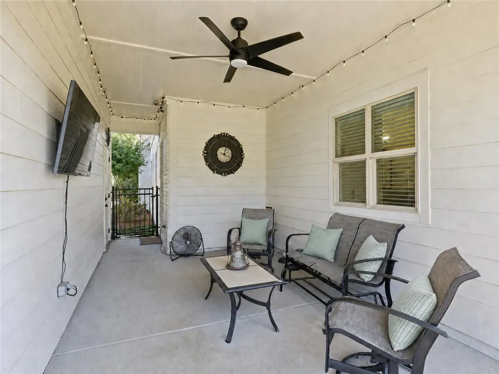 The breezeway provides comfortable, year-round outdoor living. With a TV and plenty of room for seating, it becomes a natural gathering spot for family or entertaining guests.