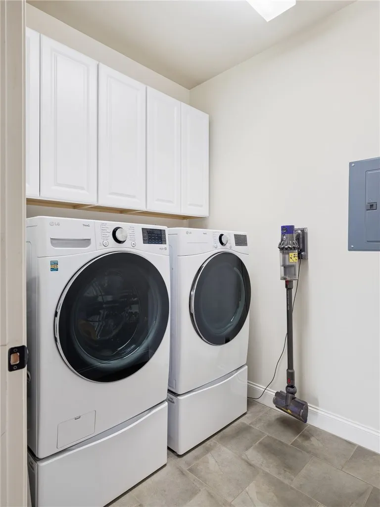 Cabinetry stretching the full width of the laundry room adds generous storage and everyday convenience.