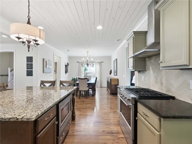 The home’s open design fosters natural movement and conversation across the kitchen, living room, and dining area.