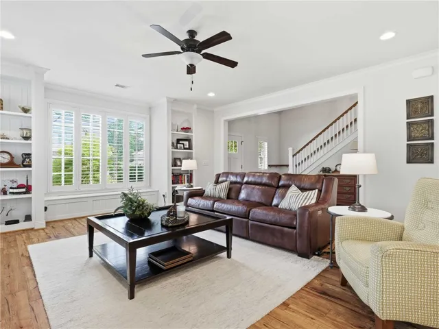The living room features a wall of windows above a window seat, framed by custom built-ins.