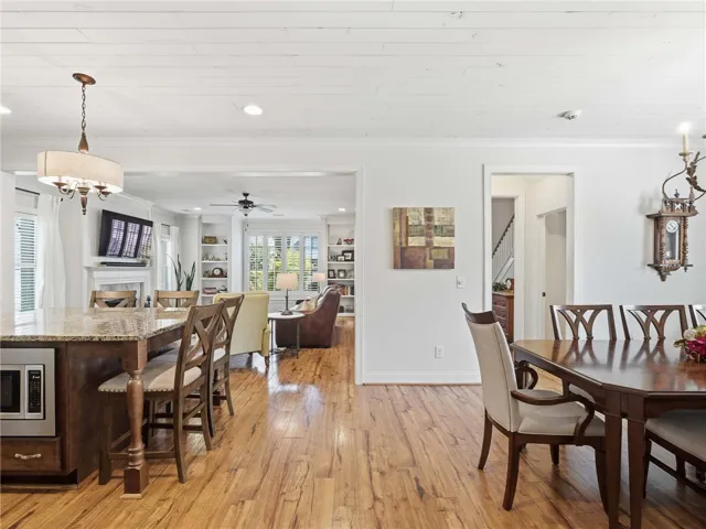 The home’s open design fosters natural movement and conversation across the kitchen, living room, and dining area.