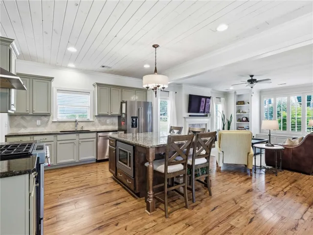 Tongue and groove ceiling, a hint of green in the cabinetry and warm tones, make the kitchen a shA tongue-and-groove ceiling paired with subtle green cabinetry and warm accents creates a kitchen that feels effortlessly welcoming