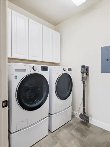 Cabinetry stretching the full width of the laundry room adds generous storage and everyday convenience.