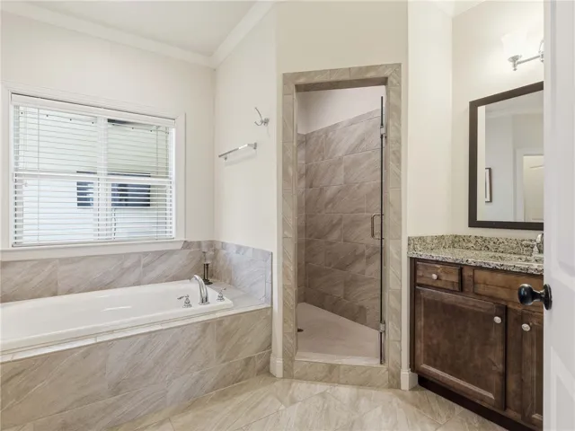 The primary bath includes a large soaking tub, two vanities, a water closet, and a walk-in tiled shower.