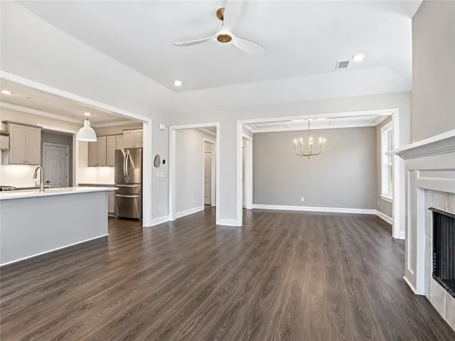 Rich wood floors flow seamlessly through this open-concept layout connecting the living and dining areas.