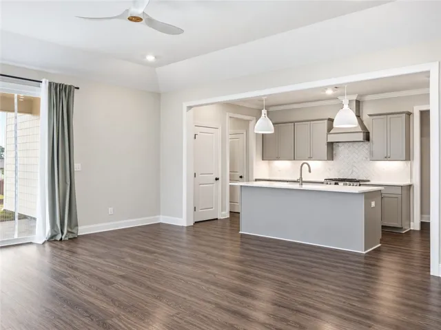 Hardwood floors and tray ceilings elevate this seamless transition between living and kitchen spaces.