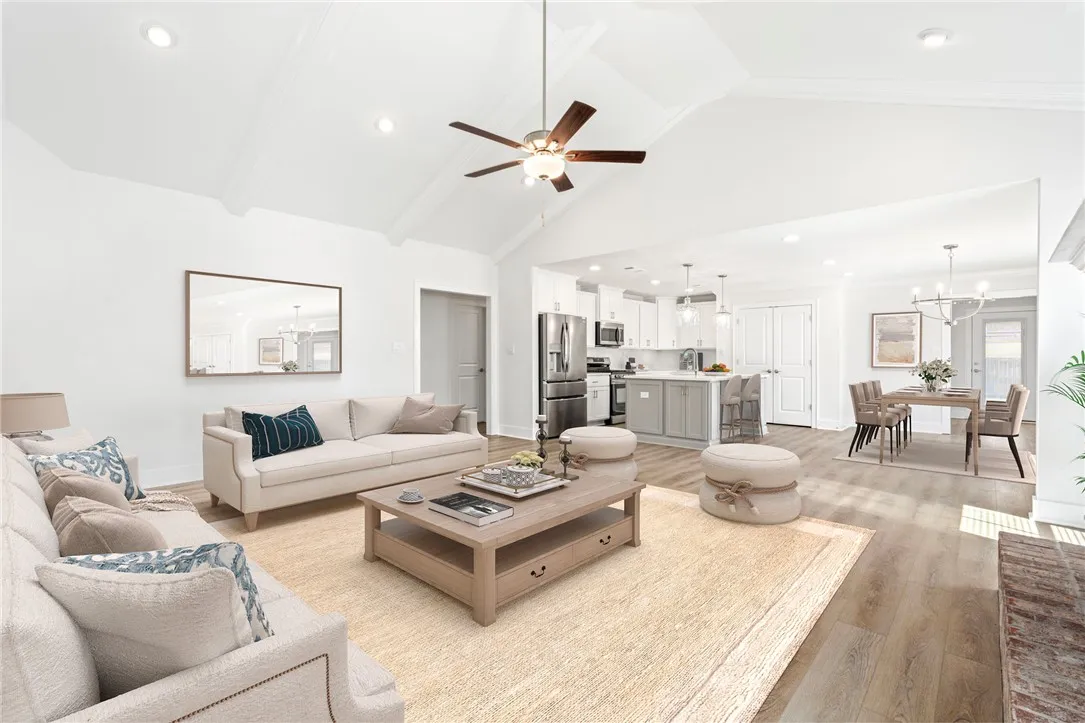 Virtually stage-Vaulted ceilings and beautiful flooring enhance the inviting, open layout of this main living area.