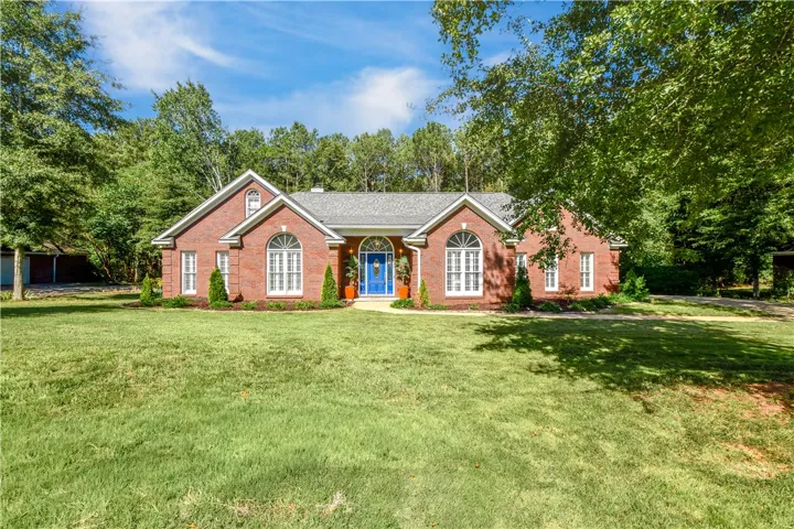 Classic brick architecture anchors this sprawling residence framed by mature trees and manicured lawns.