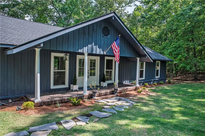 Newly painted cedar siding pairs with a stone path leading to the covered porch.