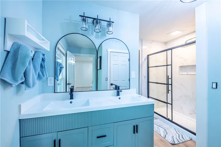 A contemporary dual vanity paired with a glass-enclosed shower highlights this modern bath space.